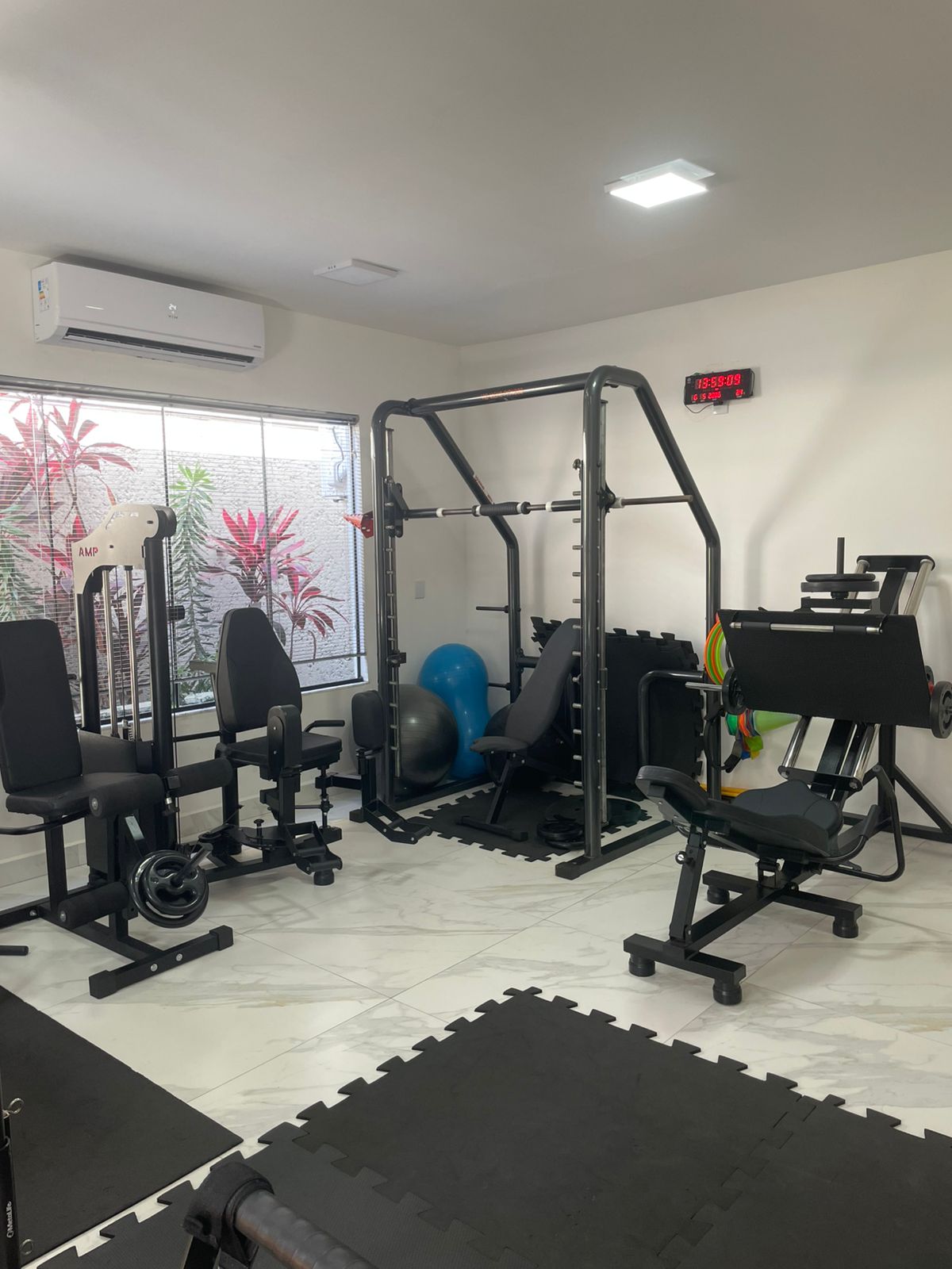 Sala de fortalecimento do Studio Sênior com aparelhos de musculação e cronômetro.