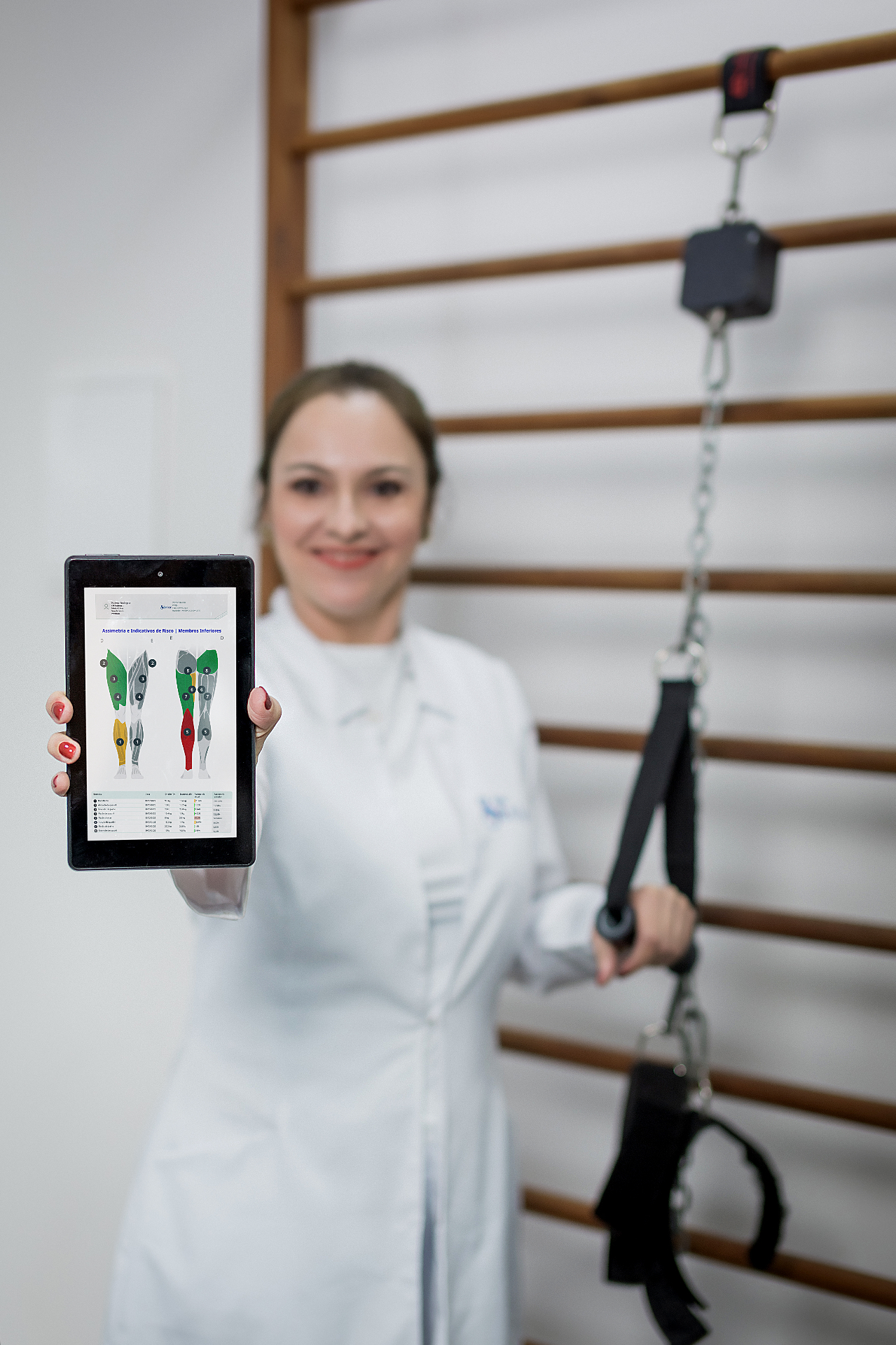 Fisioterapeuta do Studio Sênior apresentando relatório de avaliação funcional em tablet.